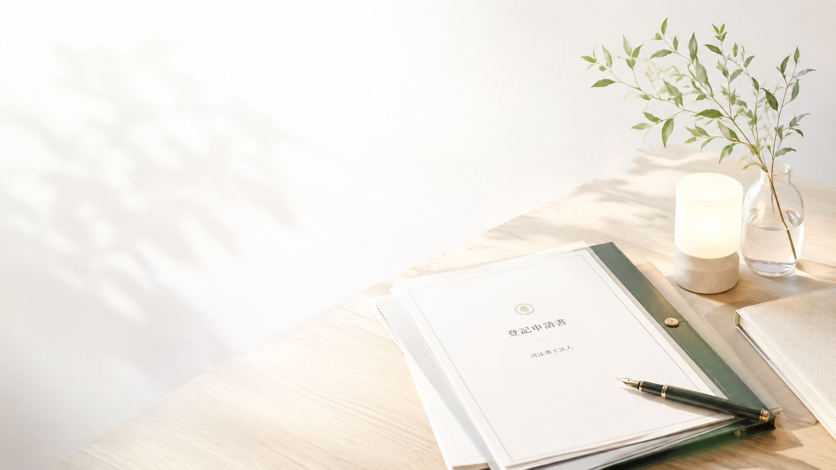 灯りと植物、登記申請書が置かれた明るい机